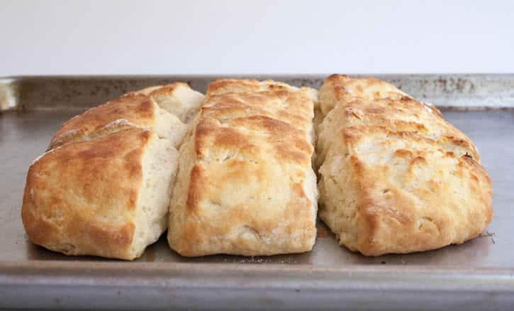 Fluffy Buttermilk Biscuits fresh out of the oven on a baking tray from themerchantbaker.com