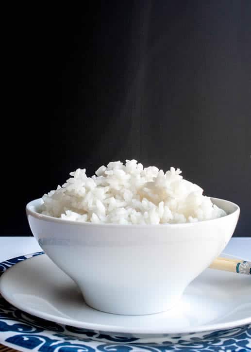 A bowl of Perfect White Rice with steam rising from it from themerchantbaker.com