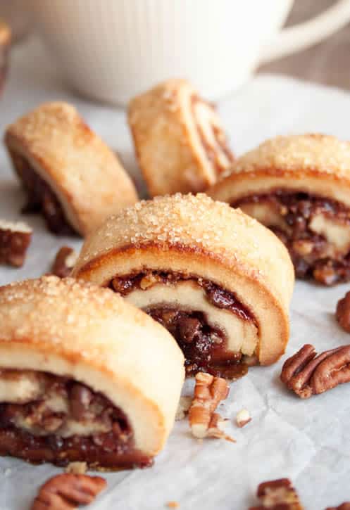 Raspberry Rugelach on parchment paper with walnuts by themerchantbaker.com