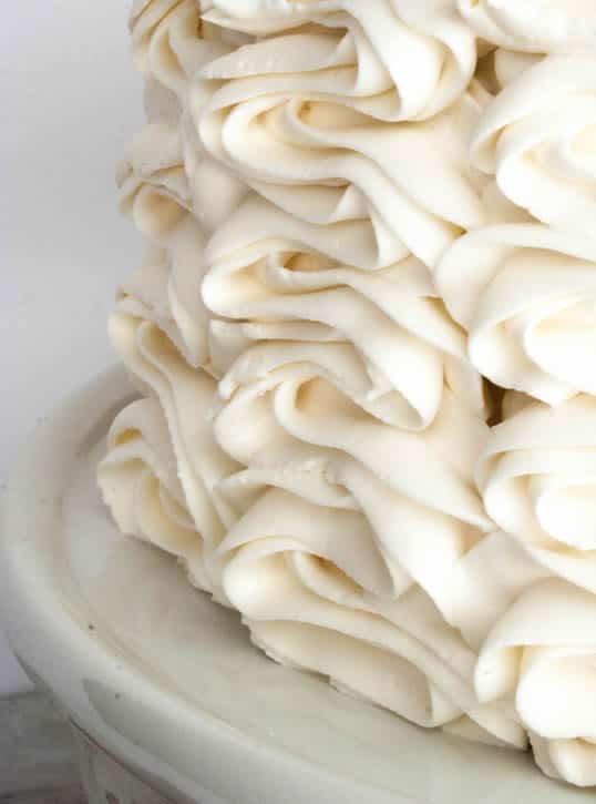 Whipped Cream Cream Cheese Frosting piped on side of cake from themerchantbaker.com