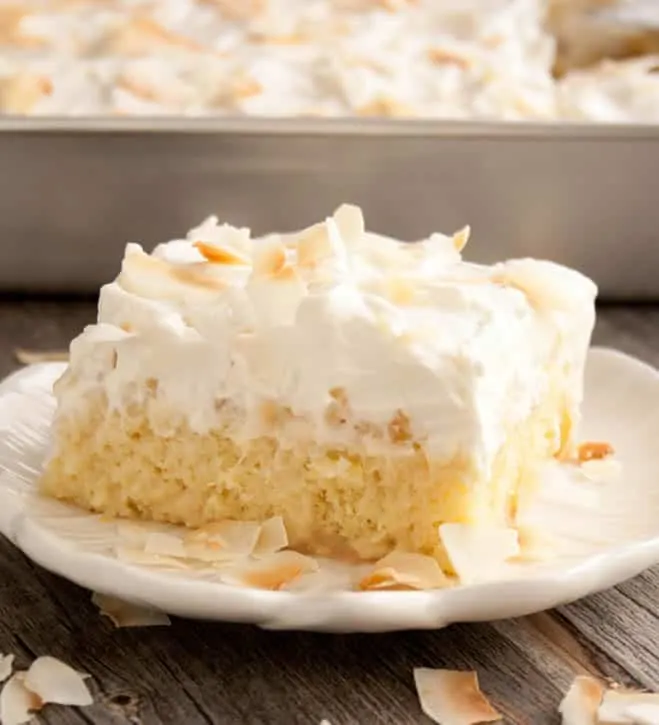 Pineapple Coconut Tres Leches Cake on a serving dish from themerchantbaker.com
