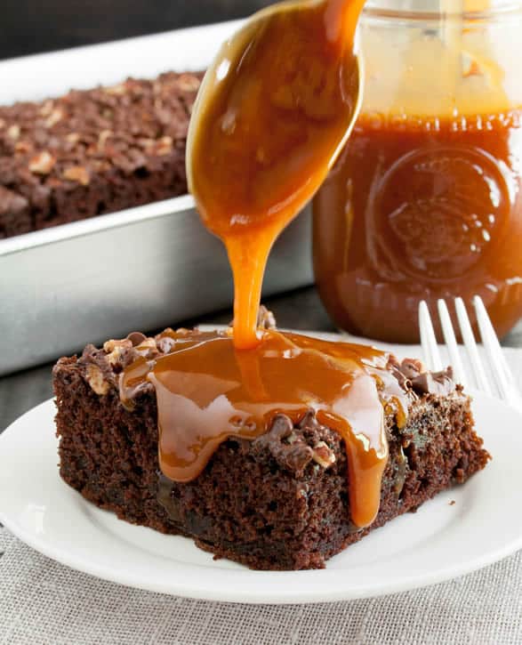 Chocolate Turtle Zucchini Cake, baked with toasted pecans and mini chocolate chips on top, then drenched with a hot buttery caramel sauce! This is one of my favorite chocolate cakes. Save some zucchini for this one!