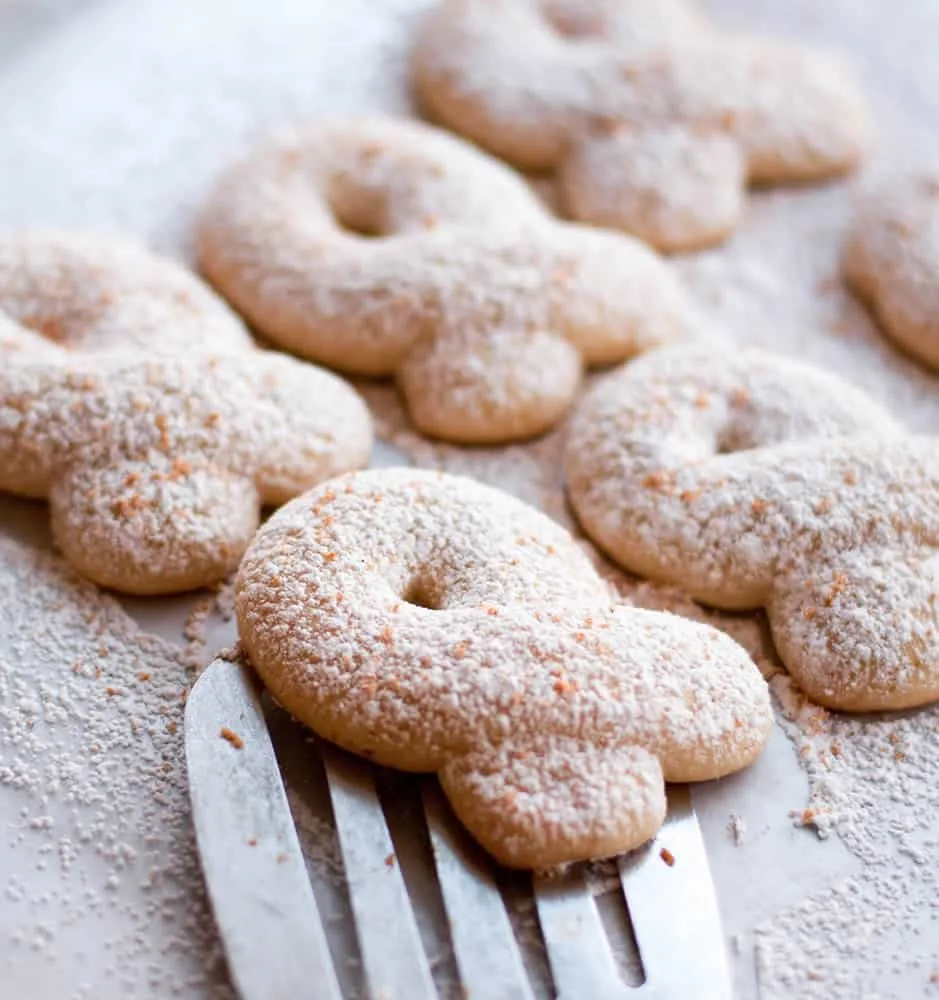 Spatula under a Eggnog Kringla on a baking sheet by themerchantbaker.com