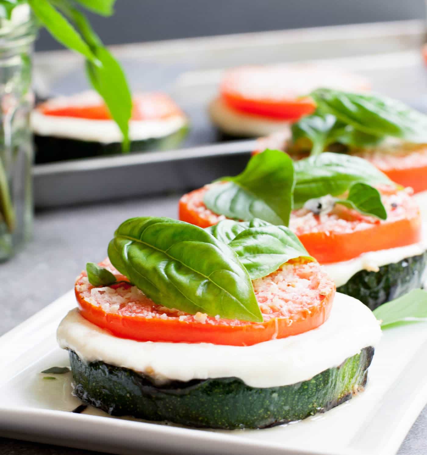 Grilled Zucchini Caprese Stacks. Thick, meaty slices of zucchini are grilled then stacked with hearty slices of tomato and fresh mozzarella. Filling enough for a main, delicious as a side or pop it onto a bun for a delicious veggie sandwich!