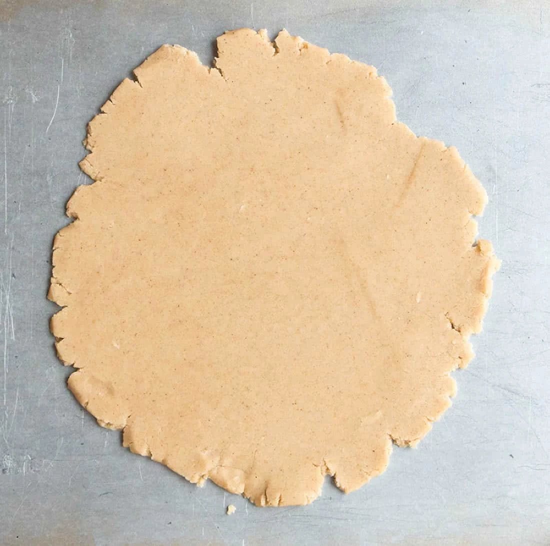 Raw dough rolled flat on a baking sheet to make Spiced Shortbread by themerchantbaker.com