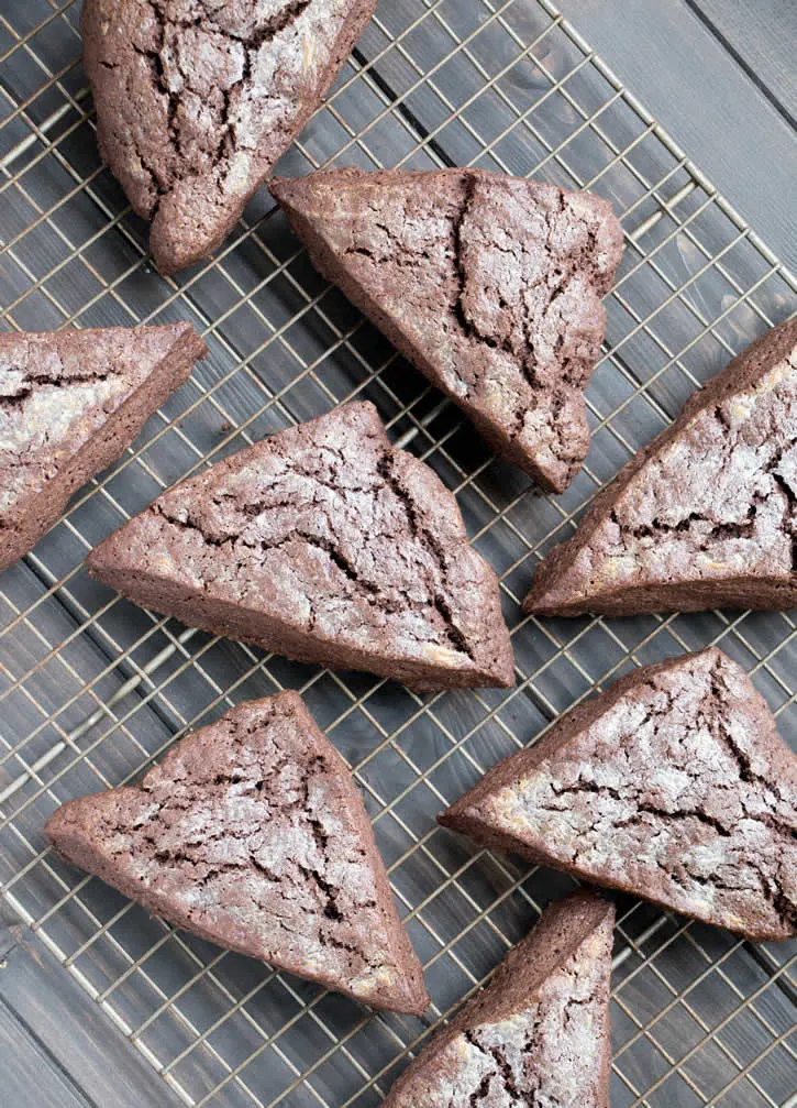 Dark Chocolate Fudge Scones are lightly sweetened, yet rich with dark cocoa, butter and cream, then topped with a dark fudgy ganache and mini chips.