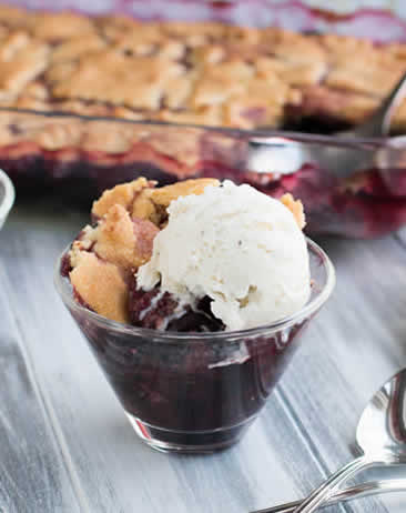 Sugar Cookie Cherry Cobbler in glass bowl with ice cream by themerchantbaker.com