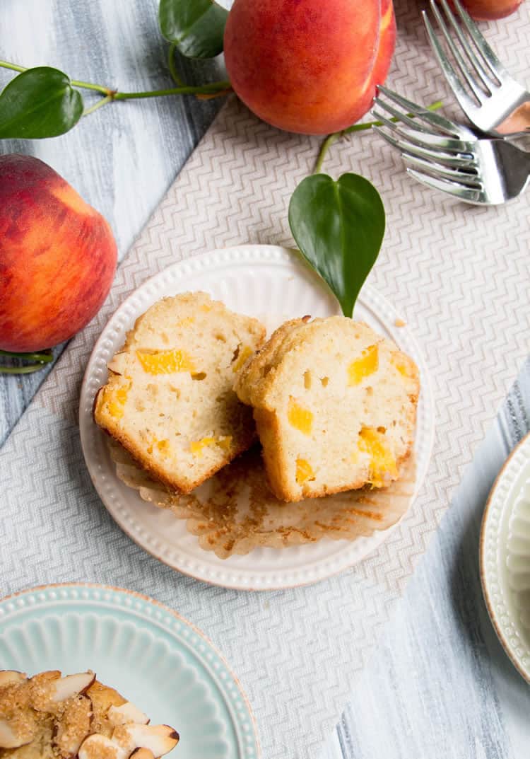 Peach Ricotta Olive Oil Muffins. Fluffy and full of fresh peaches, creamy ricotta and olive oil. A crunchy lid of almonds and raw sugar top them off!