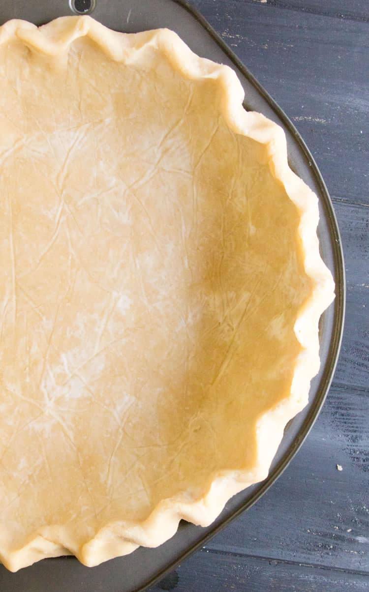 Easy All Butter Pie Crust presented in a pie pan ready to bake from themerchantbaker.com