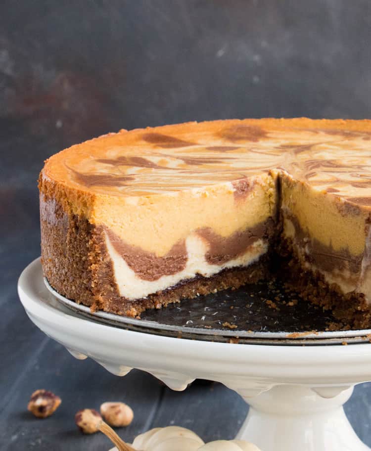 Triple Layer Pumpkin Nutella Cheesecake. Three flavors of cheesecake, a bonus layer of pure Nutella on the bottom, on a hazelnut speculoos cookie crust!