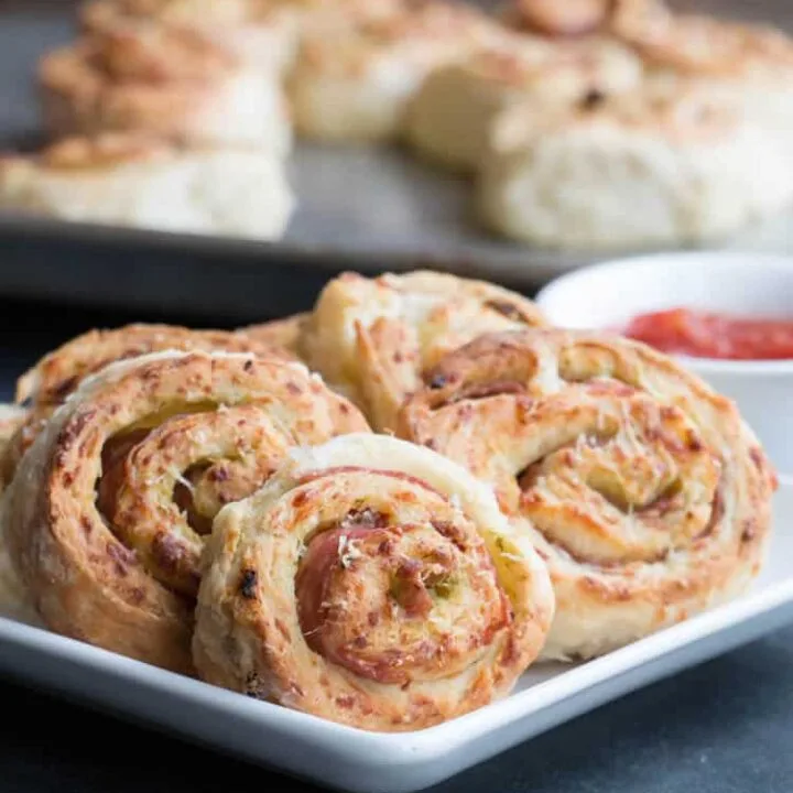 Sun-Dried Tomato Pesto Pizza Rolls made with homemade buttermilk biscuit dough that's full of mozzarella and sun-dried tomatoes, then rolled with pesto and salami. A perfect appetizer or snack. Delicious with soups and salads!
