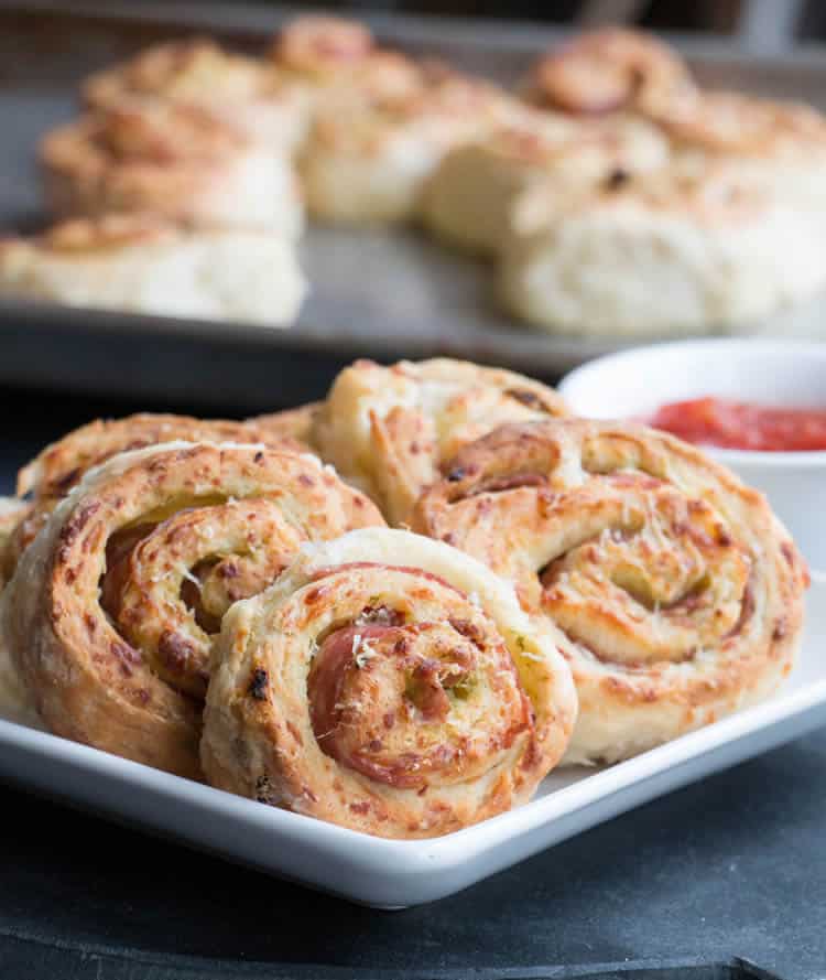 Sun-Dried Tomato Pesto Pizza Rolls made with homemade buttermilk biscuit dough that's full of mozzarella and sun-dried tomatoes, then rolled with pesto and salami. A perfect appetizer or snack. Delicious with soups and salads!