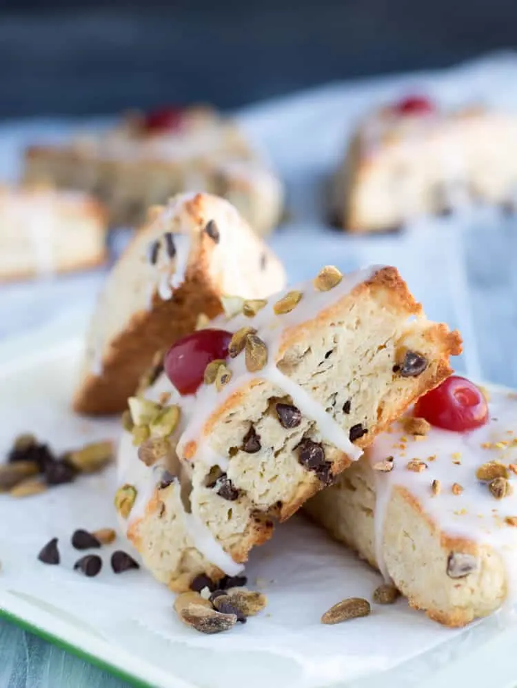 Chocolate Chip Ricotta Cannoli Scones are deliciously rich with butter and ricotta cheese, covered in a thin cherry vanilla glaze, then sprinkled with chopped pistachios and cherries!