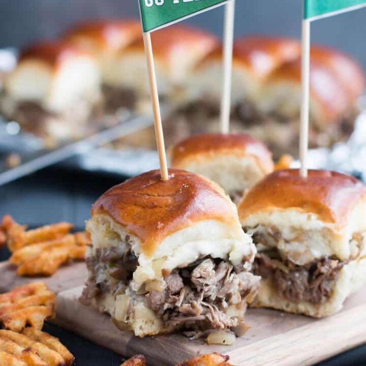 Philly Cheesesteak Sliders. Tender shaved steak, fried onions and mushrooms, melty cheese and a buttery toasted bun make these sliders a delicious choice for game day. Free printable pennants make them fun!