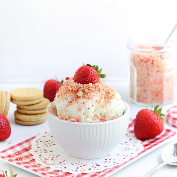 Strawberry Shortcake Ice Cream Topping on vanilla ice cream in a bowl with strawberry on top from themerchantbaker.com