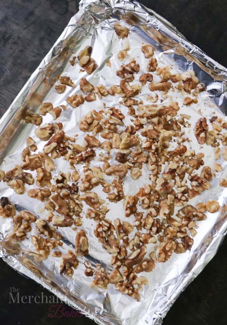 overhead view of walnuts on a foil lined baking sheet