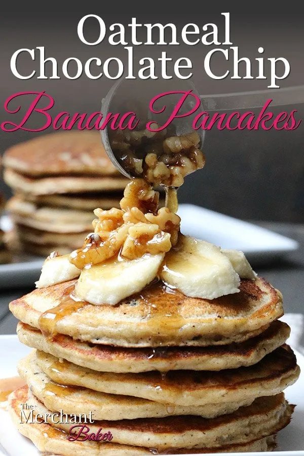 Pinterest Image Walnut syrup being ladled over a stack of Oatmeal Chocolate Chip Banana Pancakes topped with sliced bananas from themerchantbaker.com