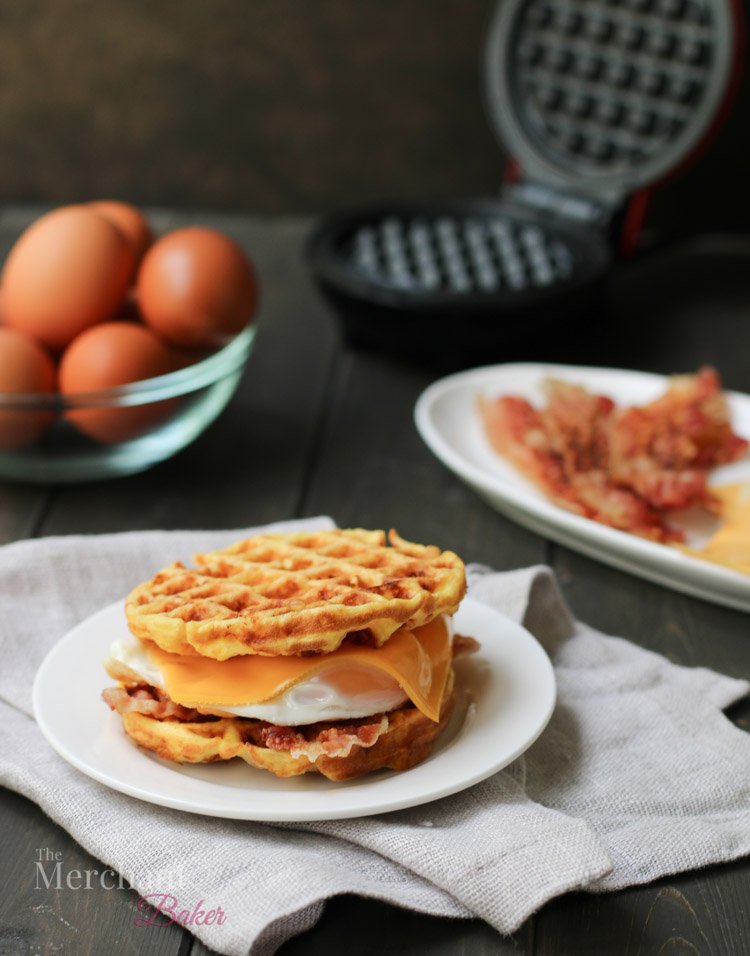 A side photo of Basic Chaffles made into a bacon, egg and cheese sandwich by themerchantbaker.com