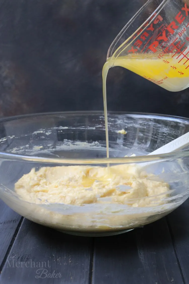 Pouring butter into cake batter for Easy Cannoli Breakfast Cake by The Merchant Baker