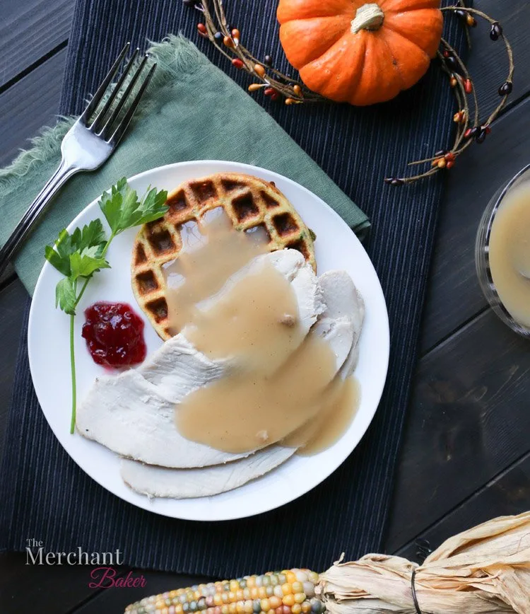An overhead photo of slices of turkey, cranberry sauce and Low Carb Stuffing Chaffles on a plate by themerchantbaker.com