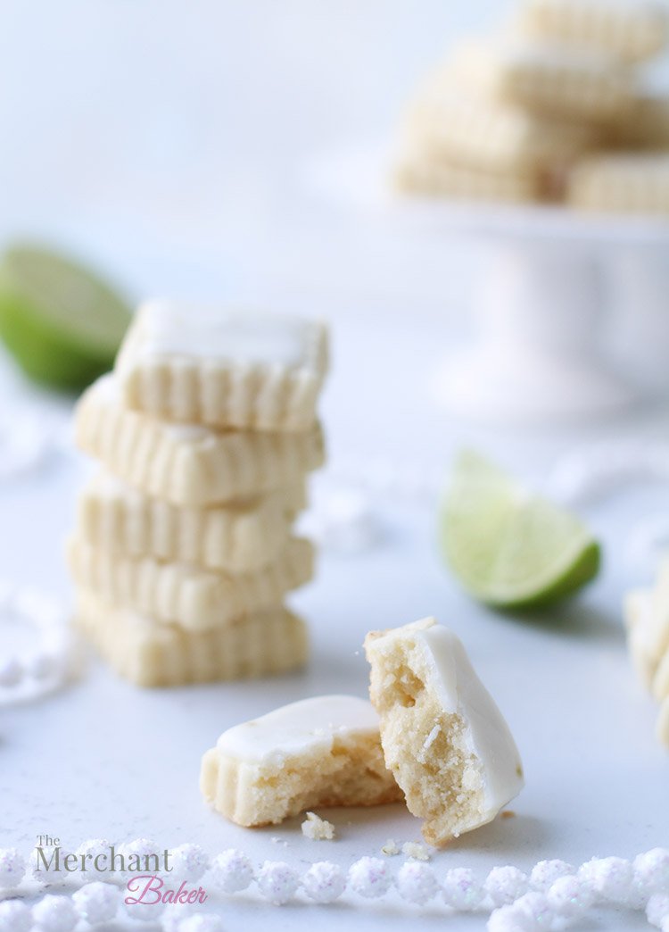 Stack of iced lime meltaway cookies cut into square shapes with one cookie broken in half to show texture