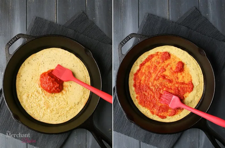 Two overhead images showing sauced being applied to Socca Pizza crust in an iron skillet by themerchantbaker.com