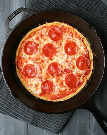 overhead of socca pizza in a cast iron pan