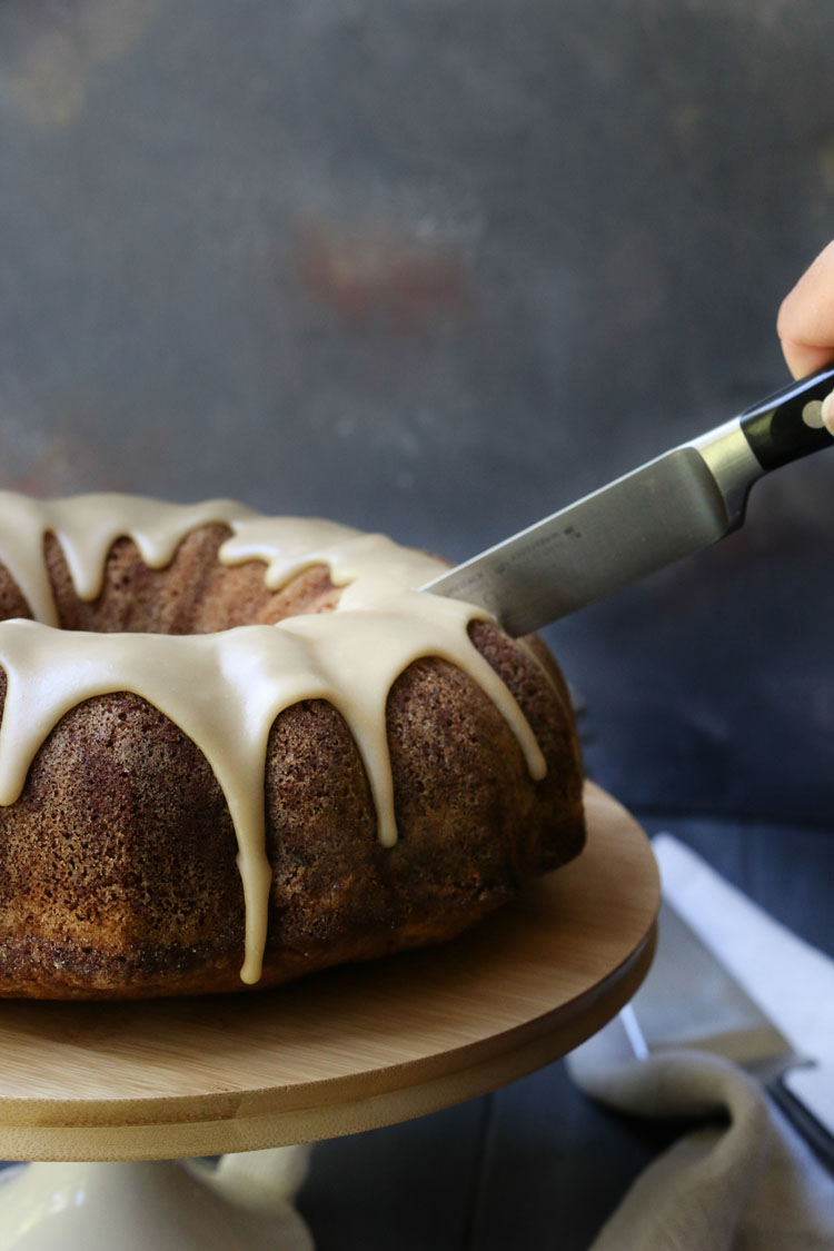 A knife slicing an apple pie bundt cake by themerchantbaker.com