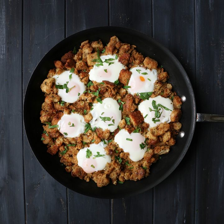 overhead view of eggs nestled in stuffing in a skillet
