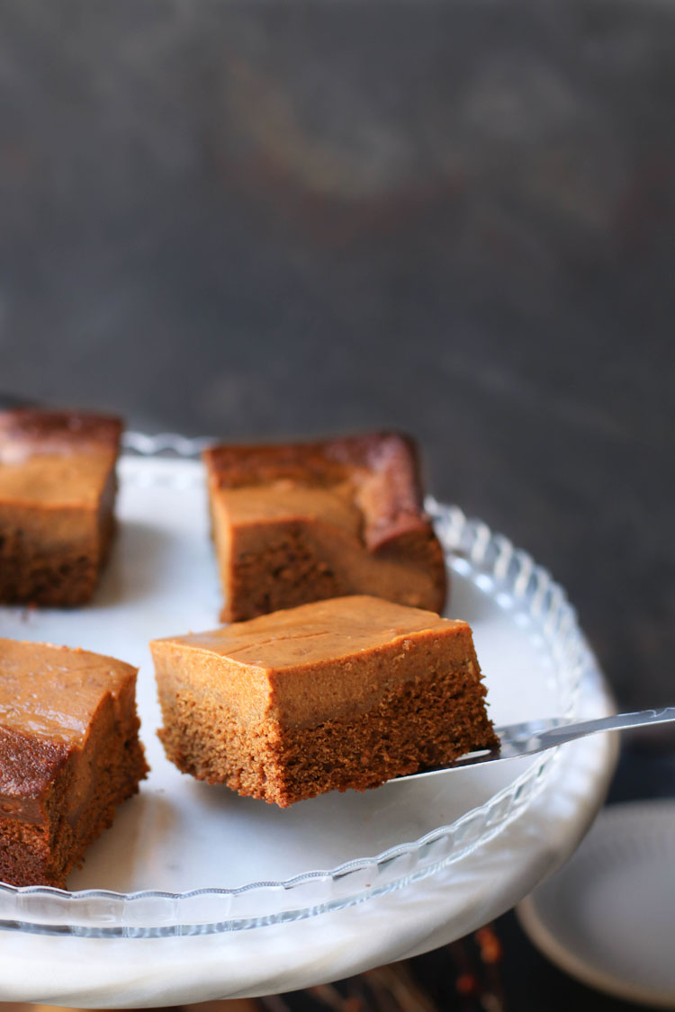 metal spatula placing a square of pumpkin pie gingerbread on a serving platter
