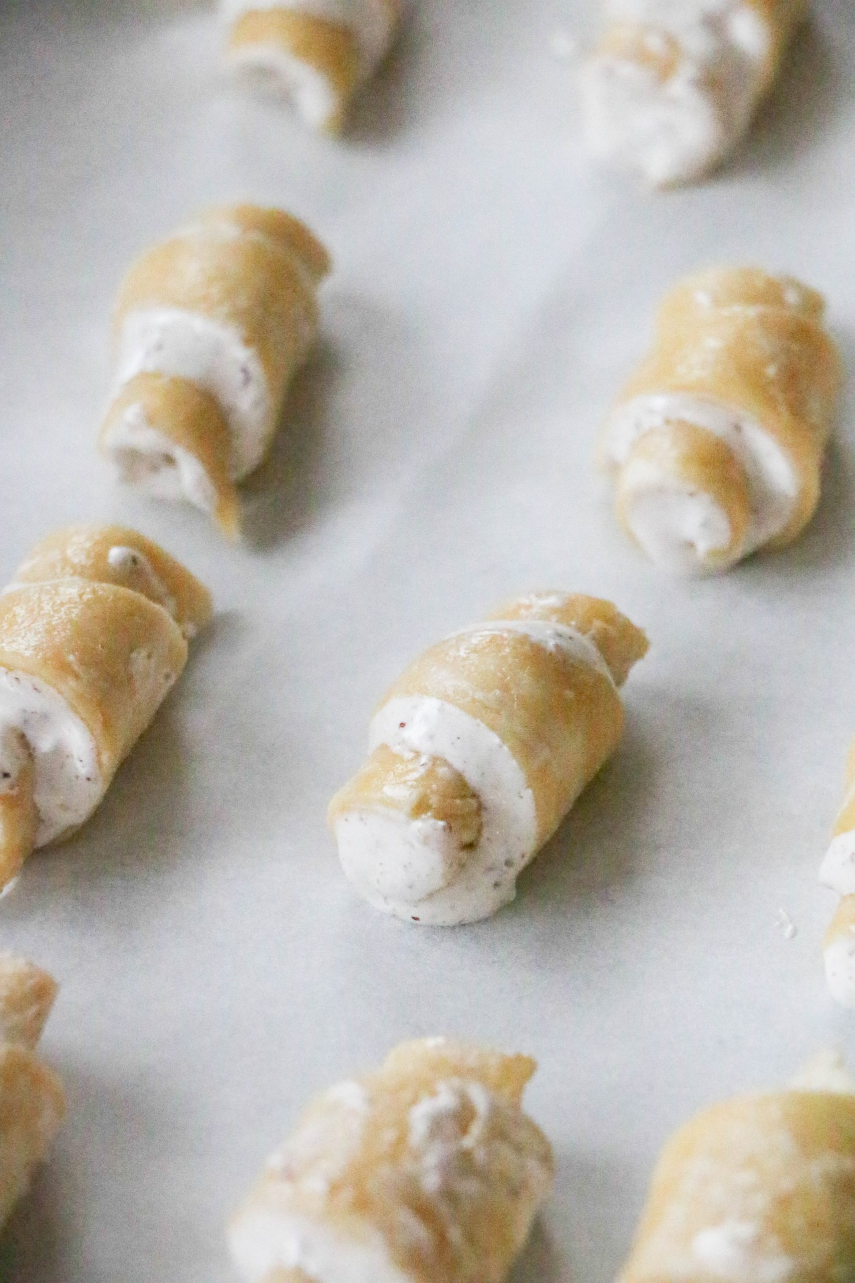 close up of unbaked butter nut horns on baking sheet