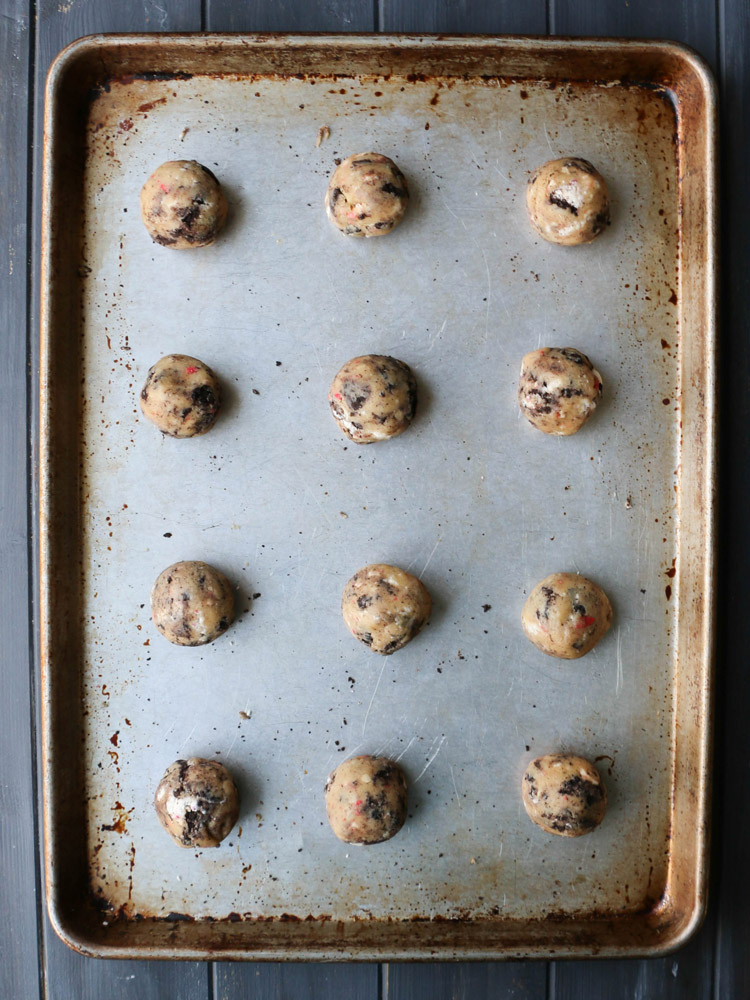 overhead view of chewy peppermint cookies and cream cookie dough rolled into balls on a cookie sheet