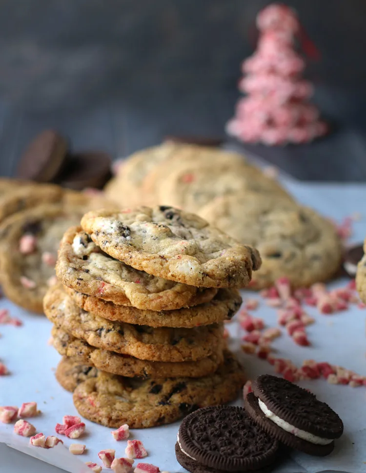 Stack of Chewy Peppermint Cookies and Cream Cookies surrounded by Andes Peppermint Crunch Baking Chips and Trader Joe's Candy Cane Joe Joe's