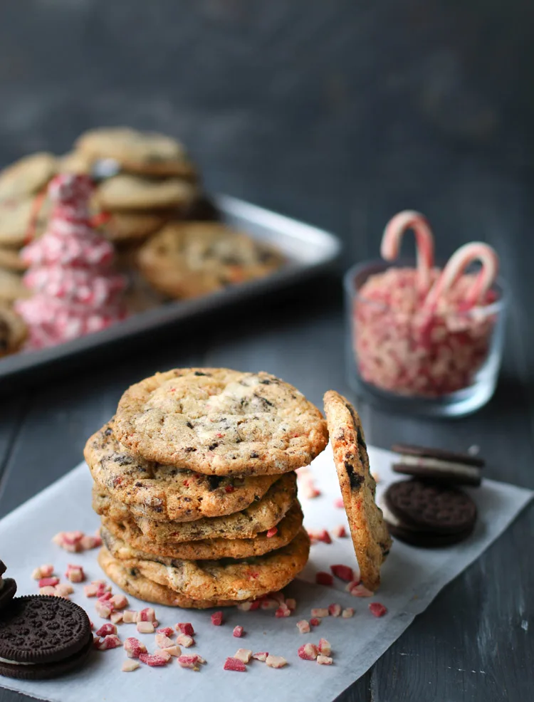 Stack of Chewy Peppermint Cookies and Cream Cookies surrounded by Andes Peppermint Crunch Baking Chips and Trader Joe's Candy Cane Joe Joe's