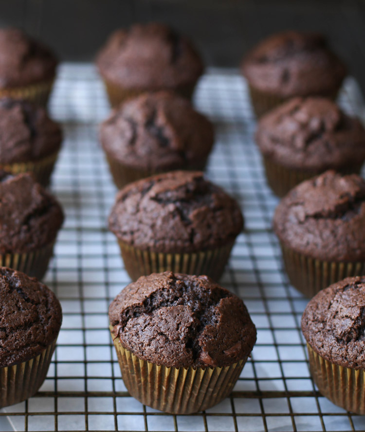 Side view of baked chocolate muffins on a wire grid cooling rack