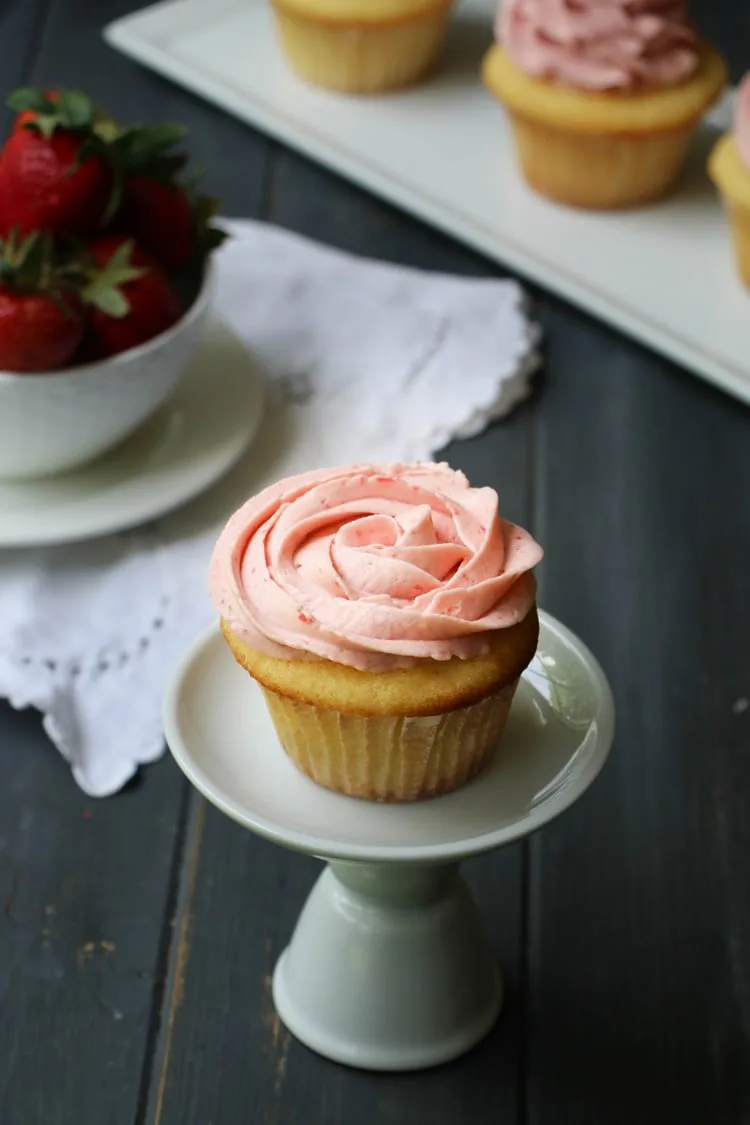 Strawberry Whipped Cream Cream Cheese Frosting piped on a vanilla cupcake in a rose design