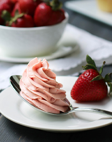 Strawberry Whipped Cream Cream Cheese Frosting on a spoon.