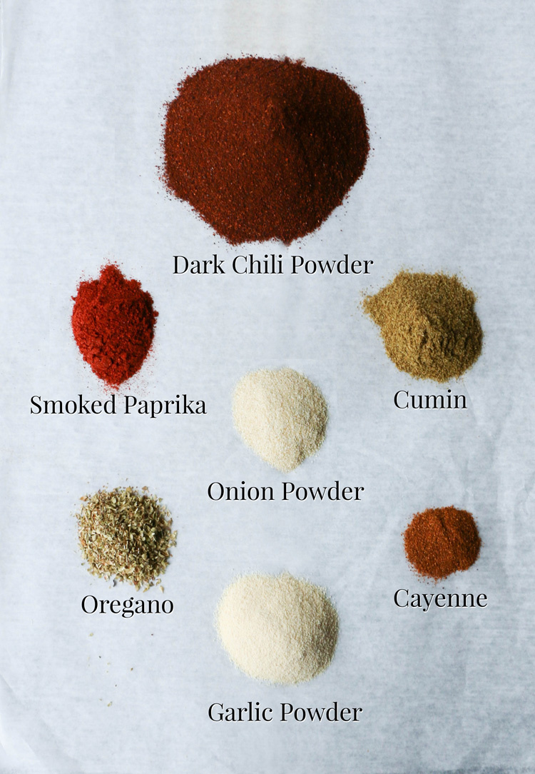 Various spices in small piles on parchment paper that will be used to make big batch turkey chili.
